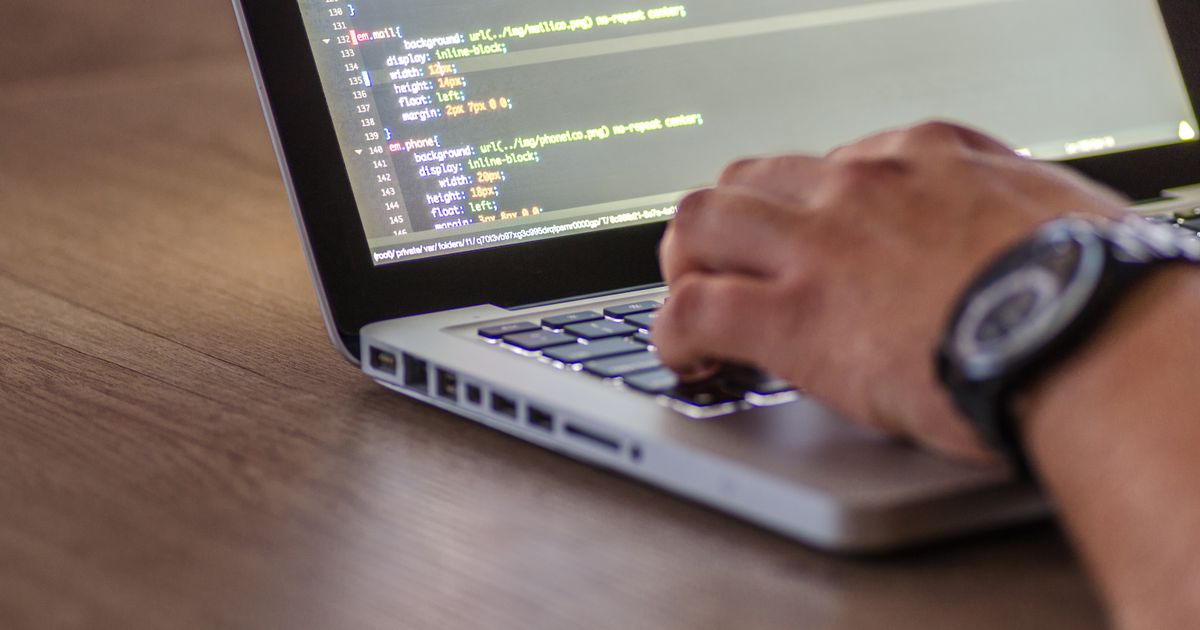 ノートパソコンでシステムを開発しているイメージ